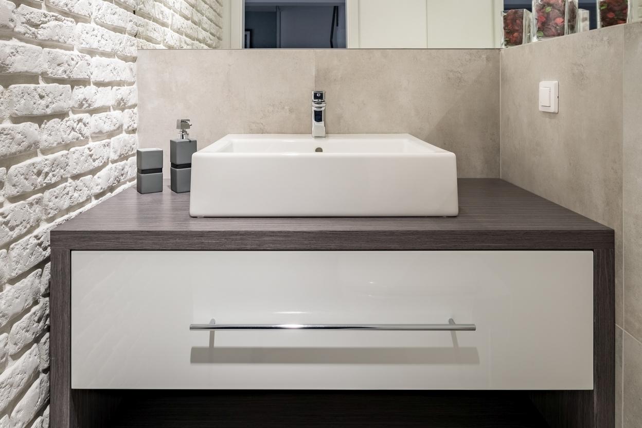 Nischenlösung für Waschtisch im Gäste-WC mit weißer Schublade an Betonwand Waschtischunterschrank im Gäste-WC