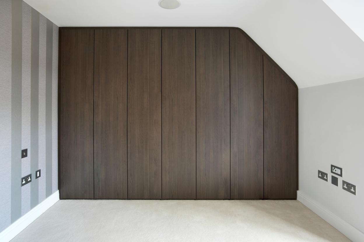 Dunkler Einbauschrank mit sieben Türen an hohem Drempel Einbauschrank mit Türen an hohem Drempel